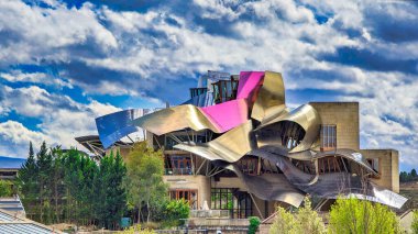 Elciego, Alava, İspanya; 28 Mart 2024: Marques de Riscal adlı Rioja şarap mahzenleri için mimar Frank O. Gehry tarafından tasarlanmış dalgalı alüminyum yapılara sahip modern bir binanın ön görünümü