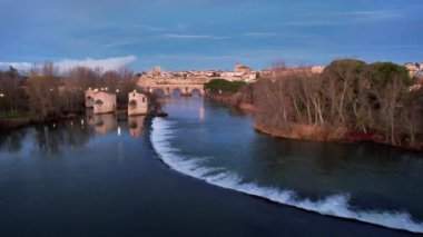 Duero Nehri boyunca ilerleyen hava aracı su değirmenlerinin yanından geçiyor ve taş köprüyü ve katedrali, Zamora, İspanya 'yı gösteriyor.