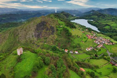 Aerial view of Penerudes medieval tower and village and Alfilorios reservoir, Morcin municipality, Asturias, Spain