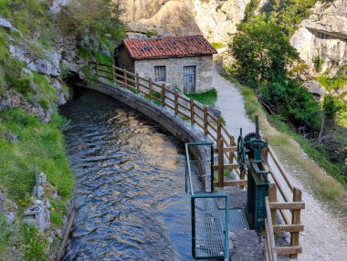 İspanya 'nın Asturias ve Leon eyaletleri arasındaki Picos de Europa Ulusal Parkı' ndaki Ruta del Cares Kanyonu 'ndaki kulübe ve su kanalları.