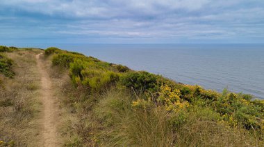 Gralha sahilinin yukarısındaki kayalıklar boyunca uzanan patika Sao Martinho do Porto, Protugal