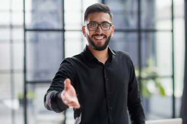 bir el sıkışma için uzanarak gülümseyen iş adamı