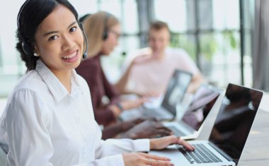 Genç Asyalı kameraman ofisteki kameraya bakıyor.