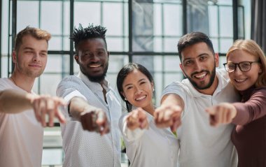 Güçlü ve yaratıcı takım. Bir grup iş adamı kameraya gülümsüyor.