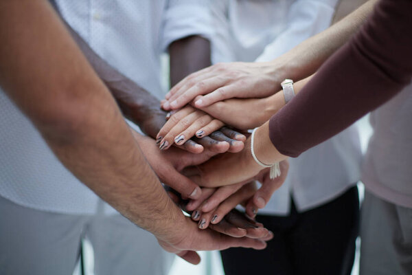 Business people joining hands in the office. concept of teamwork and partnership