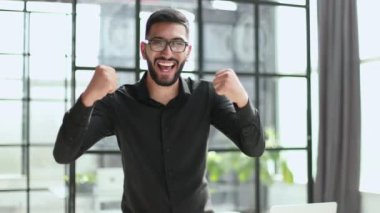 Zaferle el kaldırmış neşeli bir iş adamı.