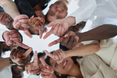 Bir grup farklı genç insan bir çember oluşturup aşağıya bakıyorlar.