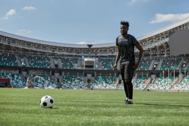 Maç sırasında Afrikalı Amerikalı futbolcu topa vuruyor