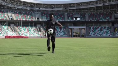 Afrikalı Amerikalı futbolcu stadyumda top tekmeliyor