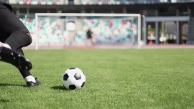 Genç futbolcu topa vuruyor.