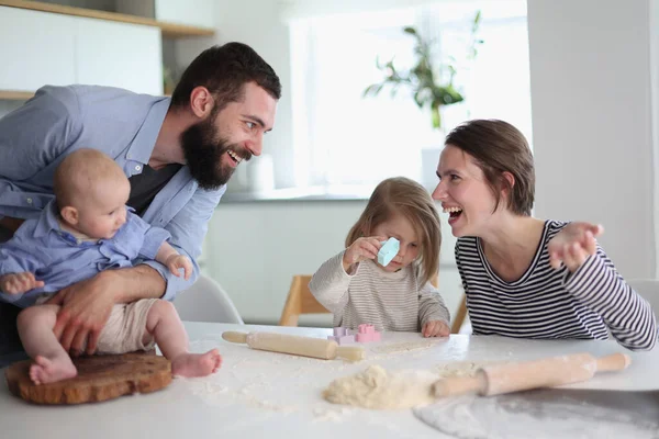 Happy parents playing with their children in the kitchen