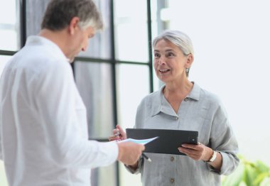 Businessman and businesswoman smiling looking at phone