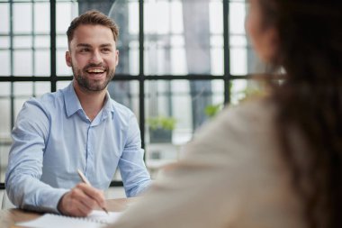 Modern bir ofiste sakallı yakışıklı bir adam.