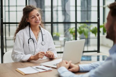 Hasta muayene eden doktor elleri yakın çekim. Hasta doktor ofisinde oturuyor.