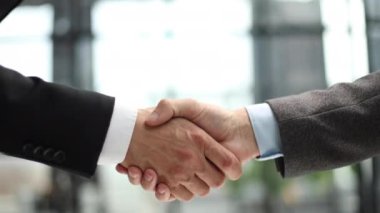Ofis toplantısında iki farklı profesyonel iş adamı yönetici lider el sıkışıyor.
