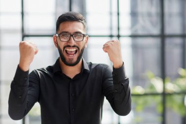 Stadyumdaki iş adamı, havayı yumrukluyor, alçaktan bakıyor.