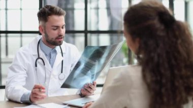 Doctor observing x-ray, patient waiting for diagnosis