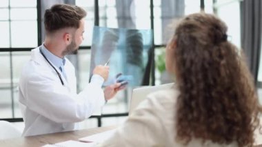 Doctor observing x-ray, patient waiting for diagnosis