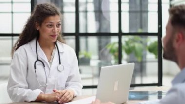 Doctor talking to patient in hospital, taking notes