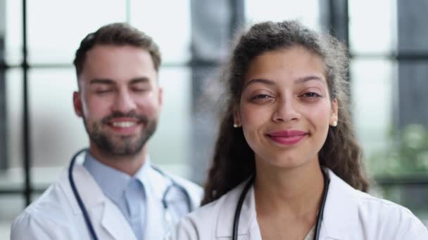 一位英俊快乐的男医生站在女同事身边 — 图库视频影像