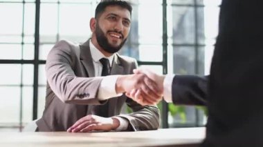 İş adamları toplantı masasında el sıkışıyor..