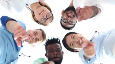 a group of different doctors pointing with the finger looking down