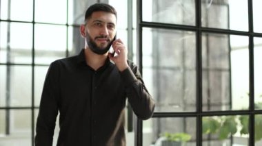 Young happy smiling urban professional man using smart phone