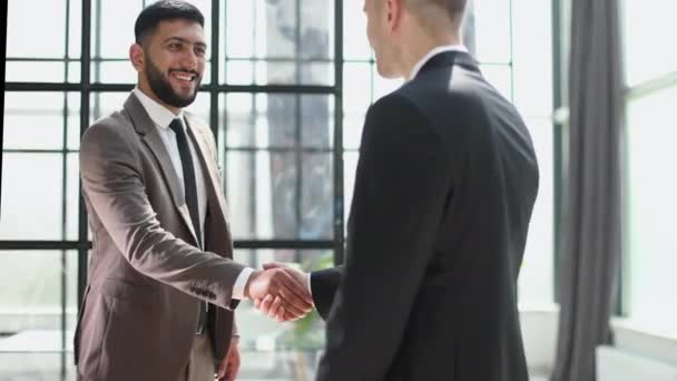 Two Confident Businessmen Shaking Hands Smiling While Standing Office — Stock video