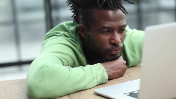 Молодой Африканский Американец Зеленом Свитере Смотрит Экран Монитора — стоковое видео
