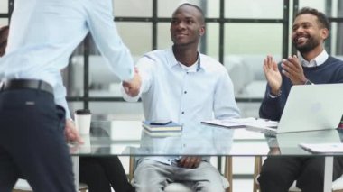 Overjoyed multiethnic businessmen shake hands greeting getting acquainted in office