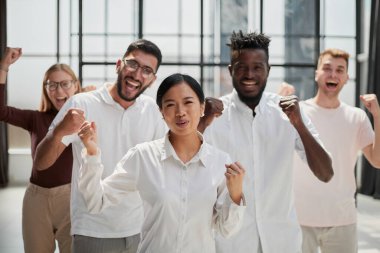 Modern bir ofiste iş toplantısı sırasında kameraya bakan iş adamları.