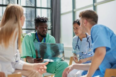 Ameliyata hazırlanırken röntgene bakan genç bir grup ağız cerrahı..