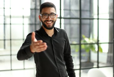 Genç işadamı, ofisteki başarısını kutluyor yumruklarını kaldırıp başarısını kutluyor.