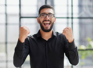 Stadyumdaki iş adamı, havayı yumrukluyor, alçaktan bakıyor.