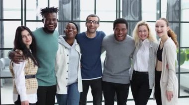 Modern bir ofisin önünde duran bir grup iş adamı.