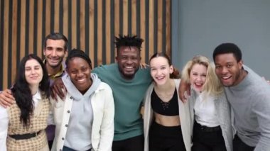 Ofiste dikilirken kameraya bakan çeşitli iş adamları.