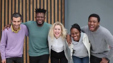 Ofiste dikilirken kameraya bakan çeşitli iş adamları.