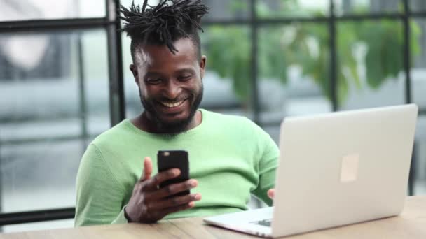 年轻商人在现代办公室用笔记本电脑和智能手机聊天的照片 — 图库视频影像
