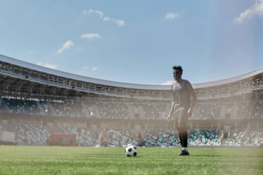 Maç sırasında Afrikalı Amerikalı futbolcu topa vuruyor