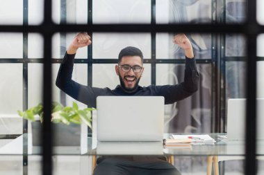 ofiste onun masasında oturan bir laptop ile iş adamı