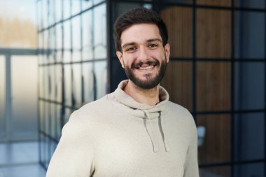 Ofis penceresinde duran kendinden emin bir iş adamının portresi.