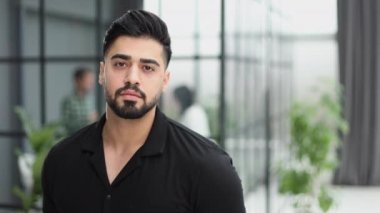 Ofiste poz veren kendinden emin genç bir işadamı.