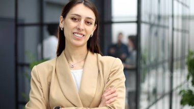 Bir müşteriyi selamlarken kameraya bakan mutlu genç bir kadın..