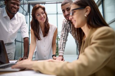Çeşitli çok uluslu takımlar yaratıcı bir ofisteki konferans odasında sohbet ediyorlar..