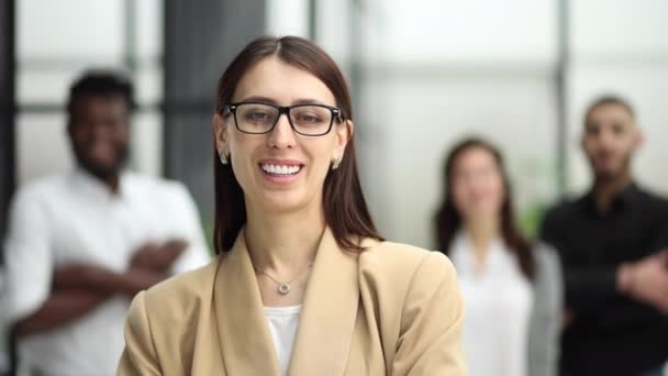 Mädchen Mit Brille Lächelt Vor Dem Hintergrund Ihrer Kollegen Büro — Stockvideo