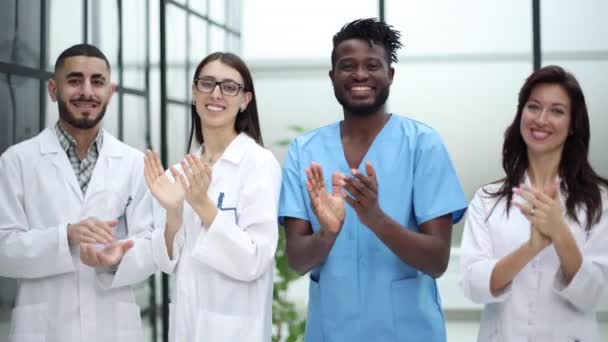 Skupina Mladých Zdravotnických Pracovníků Tleskající Svému Vůdci Když Stojí Chodbě — Stock video