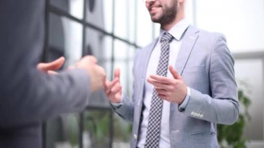İki iş adamı, pencereli bir ofis yönetim kurulunda konuşurken derin bir tartışma içindeler.
