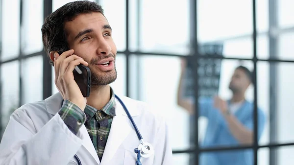 病院中に携帯電話で話す男性医師のショット — ストック写真