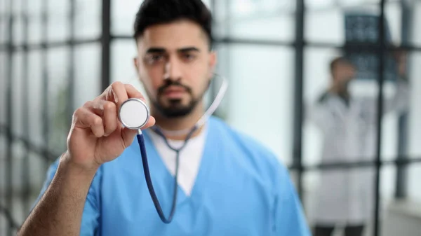 A futuristic doctor shows stethoscope and appear of advanced futuristic medicine symbols in holography.