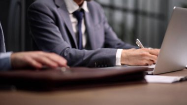 Ofisteki dizüstü bilgisayarda çalışan bir adam. Yakın plan.